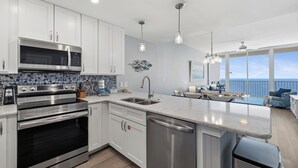 Een moderne keuken met roestvrijstalen apparatuur, een vaatwasser en een groot eiland.