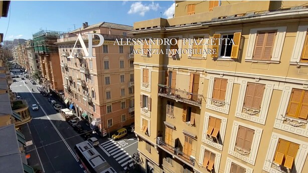 Un edificio de varios pisos con balcones y vista a la calle.