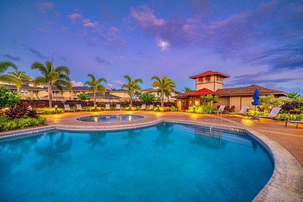 A swimming pool with lounge chairs and palm trees, surrounded by buildings with red roofs. - Pili Mai Family Condo 6G, 2 Bedroom, 2 Bath, Plus Loft with Queen Murphy Bed (Koloa)