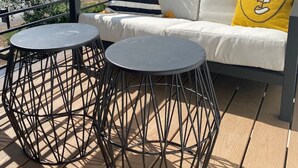 A deck with a white sofa, two round tables, and a yellow pillow. - Midtown gem I Park view I Full kitchen (Bend)
