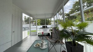 A covered outdoor area with a table, chairs, and potted plants. - Bright & Spacious Villa in Hollywood ★ 3BR/2BA ★ Heated Pool ★Walk to Beach (hollywood)