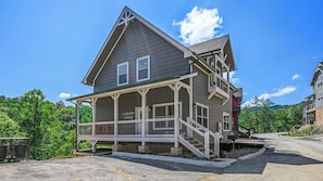 A two-story building with a porch and a staircase leading to the upper level.