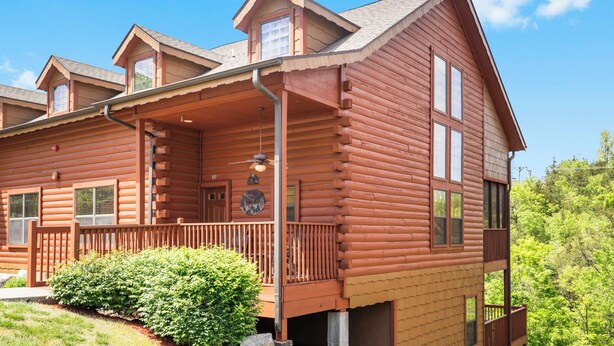 A log cabin with a balcony, multiple windows, and a chimney. - Spacious Cabin in the Heart of Branson, near shows, shopping! (Branson)