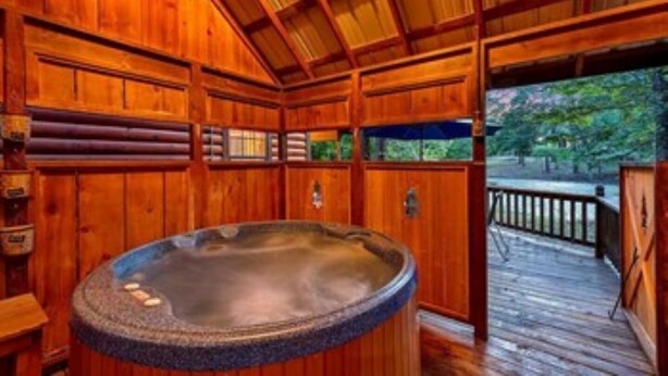 Ein Spa-Raum aus Holz mit Whirlpool, Holzwänden und einer Holzterrasse außen.