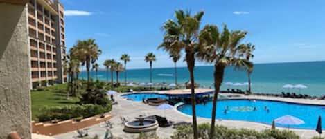 Relax by the pool surrounded by palm trees and enjoy stunning ocean views.