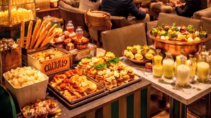 A restaurant with a buffet, a television displaying a sports event, and a warm, inviting atmosphere. - The Alest Hotel (Mexico City)