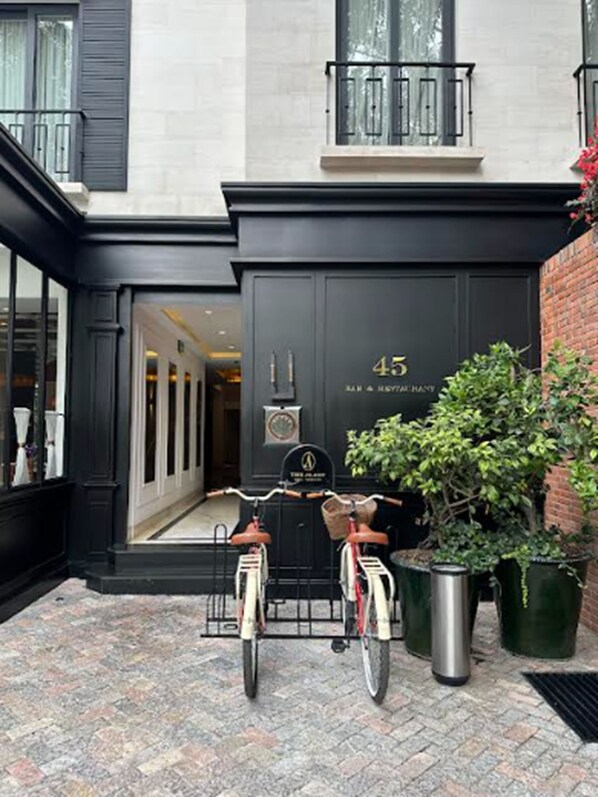 A building entrance with a black door marked "45" and a sign for "The Palace Bar & Restaurant". Two bicycles are parked in front.