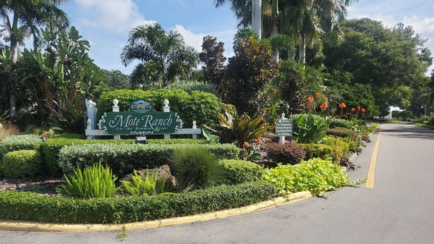A sign for Mote Ranch on the Braden River, surrounded by lush greenery and a paved road. - 4 Bedroom Pool home with pond view in Sarasota, FL (Sarasota)