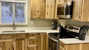 A kitchen with wooden cabinets, a stainless steel stove, and a microwave. - Timberline cabin close to Mt. Rainer and White Pass, WiFi, Netflix, AC (Packwood)
