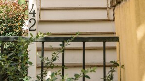 A set of beige exterior stairs leading to a building entrance, with a number '42' visible on a post. - EAST 42 C - 1 Bedroom, 1 Block to King (Charleston)