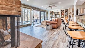 A spacious living room with a fireplace, a sofa, and a dining area with wooden tables and chairs.