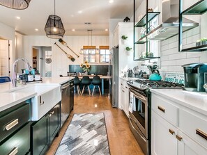 Una cocina moderna con armarios blancos, una isla central y una estufa.