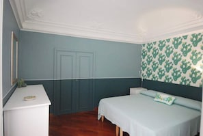A bedroom with a bed, a dresser, and a door.