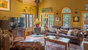 Una sala de estar acogedora con chimenea, sofá de cuero y televisor.