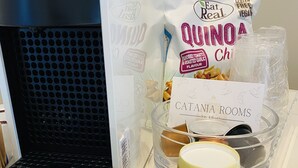 Een keuken met een koffieapparaat, een zak quinoa, een bak kattenvoer en twee koffiekopjes.