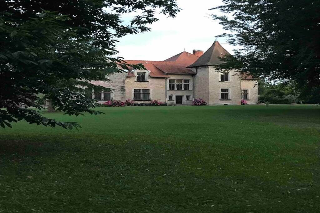 Een groot, historisch stenen gebouw met een steil dak en meerdere ramen.