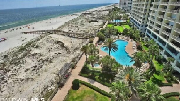 Un hotel frente a la playa con piscina, acceso directo a la playa y edificios altos.