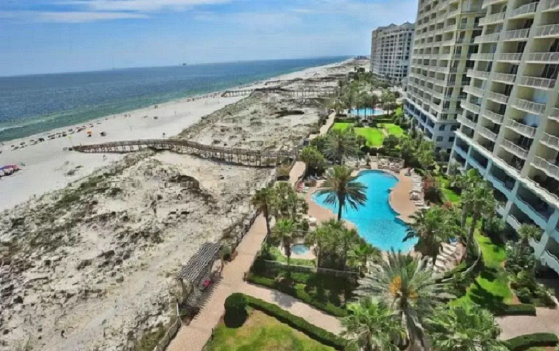 Ein Hotel direkt am Strand mit Pool, Zugang zum Strand und Hochhäusern.