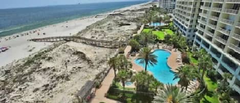Ein Hotel direkt am Strand mit Pool, Zugang zum Strand und Hochhäusern.