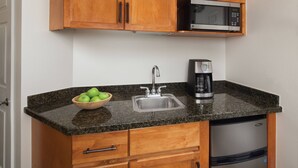 A kitchen with wooden cabinets, a granite countertop, a stainless steel sink, a microwave, a coffee maker, and a dishwasher. - Marriott Shadow Ridge - Studio Villa with King bed (Palm Desert)