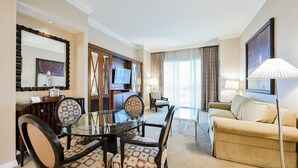 A hotel room with a dining area, a sofa, and a TV. - SVS: MGM 2BR, Mtn View, Balcony & 3 Baths (Las Vegas)