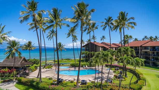 A resort with a swimming pool, palm trees, and a view of the ocean. - Spacious 3bd Papakea condo, the perfect getaway (Lahaina)