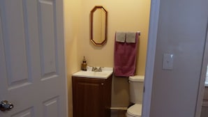 A bathroom with a wooden vanity, a toilet, and a mirror. - Big Mountain Cabins with direct access to Windrock ATV Park (OLIVER SPRINGS)