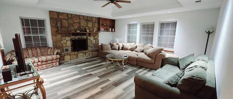 TV connectée, cheminée, table de tennis de table, livres