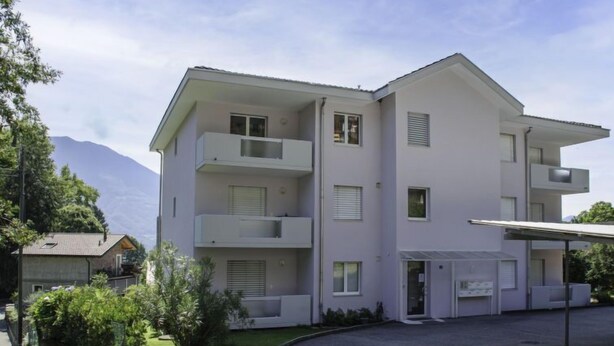 A multi-story building with balconies, a covered entrance, and a paved driveway. - Simona Fontile 11 by Interhome (Minusio)