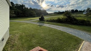 Un paysage verdoyant avec un sentier de gravier menant à une maison.