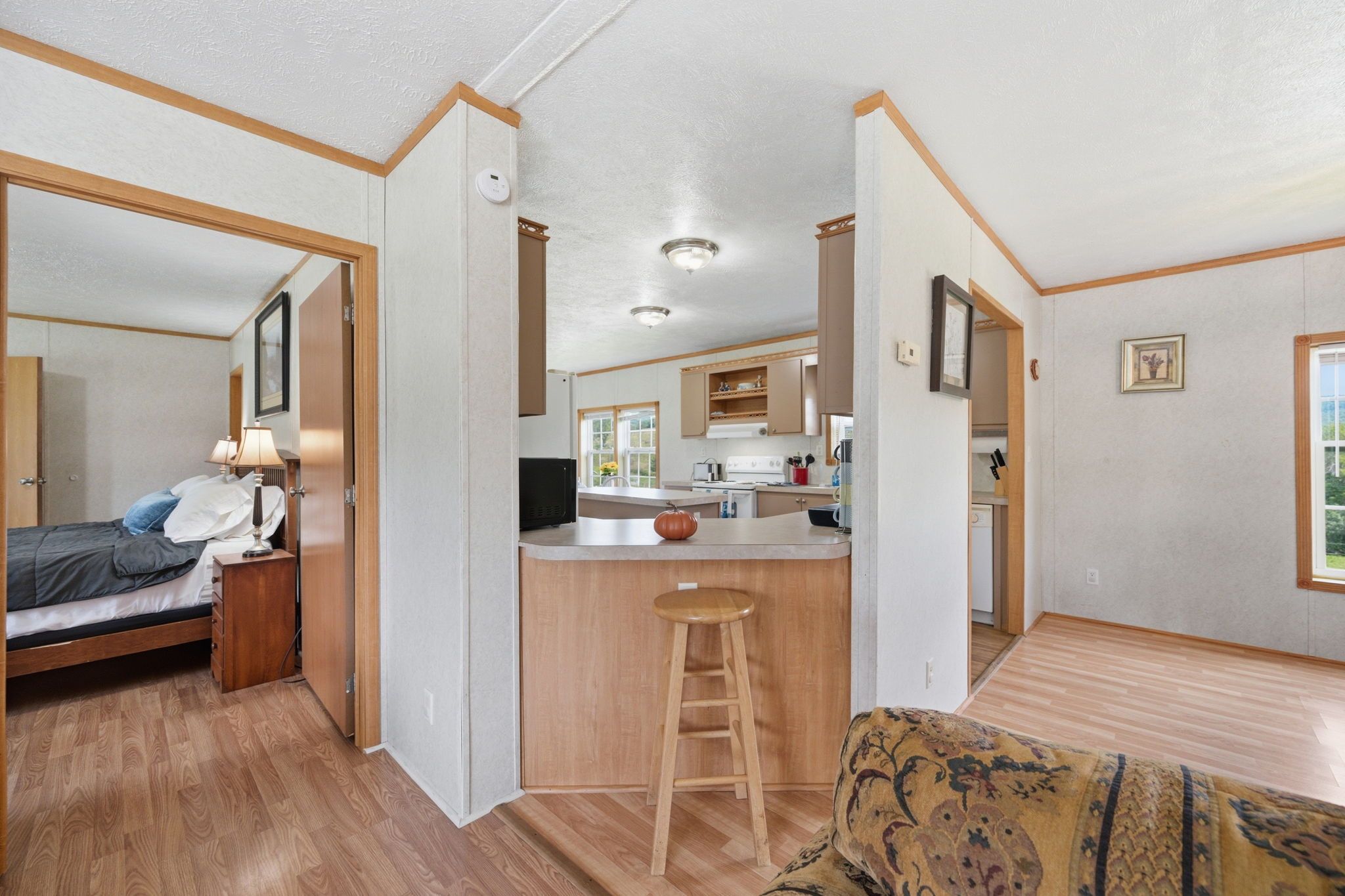 Una habitación pequeña con cama, kitchenette y zona de comedor.