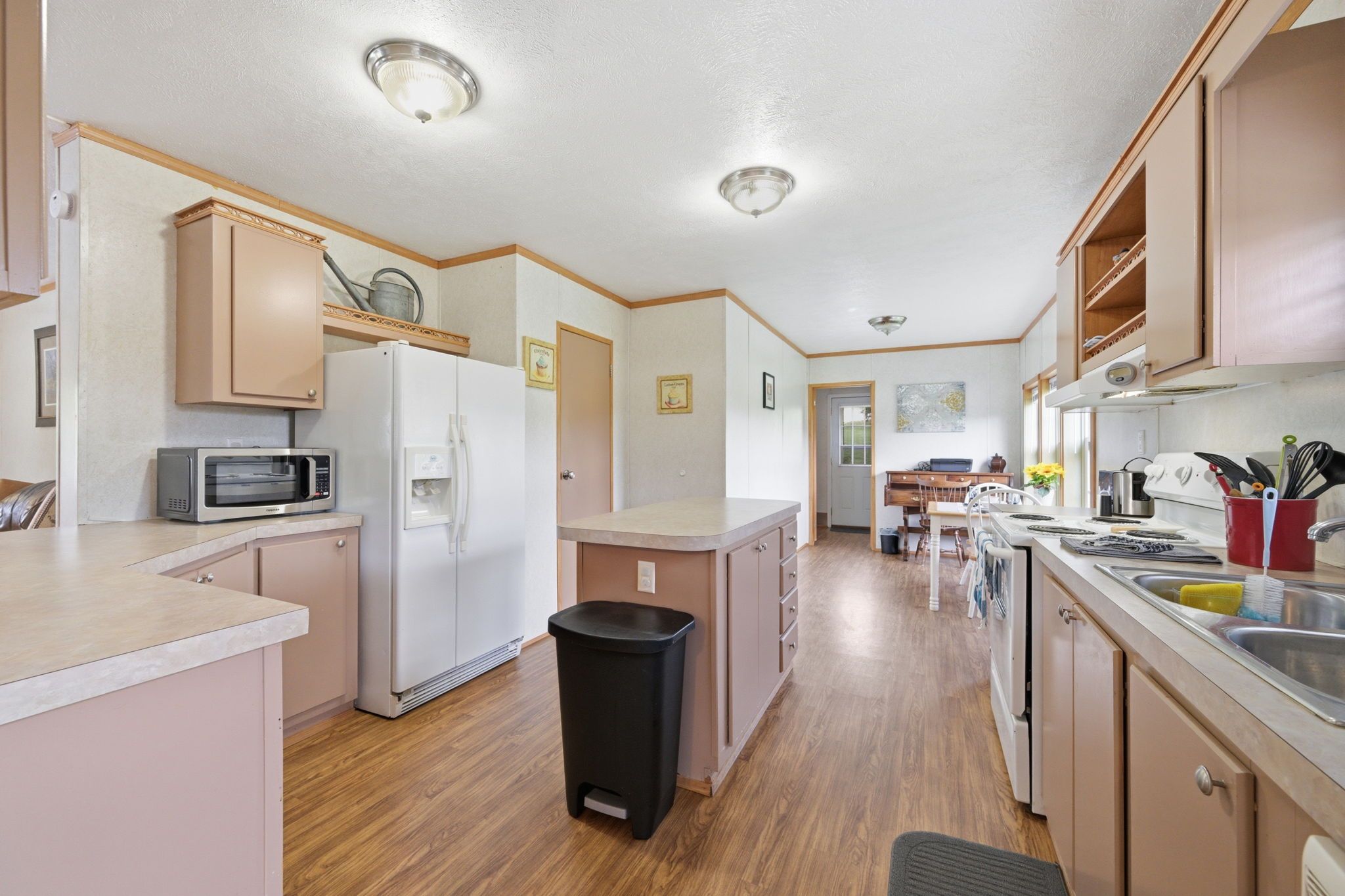 A compact kitchen with a microwave, refrigerator, and sink.