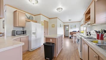 A compact kitchen with a microwave, refrigerator, and sink.