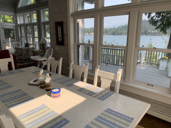 Enjoy meals with family and friends at the large dining table, taking in the serene views of the lake and surrounding forest from the balcony.