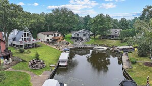 A residential area with houses, a small canal, and a dock with boats. - Lake Living on Castle Rock Lake, Close to WI Dells, Family Friendly (Mauston)