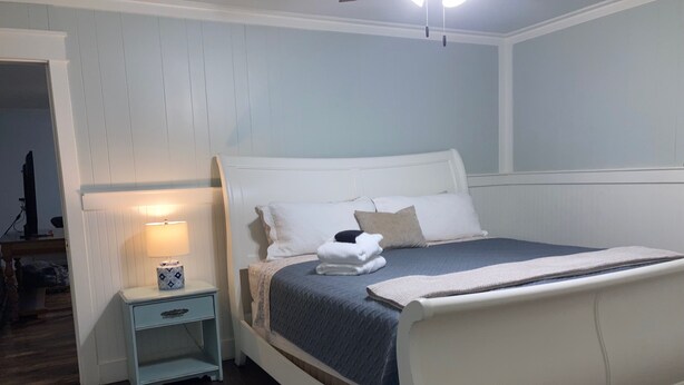 Ein Schlafzimmer mit Bett, Nachttisch und Lampe.