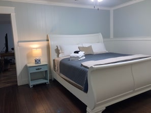 A bedroom with a bed, nightstand, and a lamp. - Tucked Away Renovated 4 Bedroom/ 2 Bath, Sleep 12 
Close to Parris Island (Beaufort)