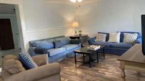 Ein Wohnzimmer mit zwei Sofas, einem Couchtisch und einer Lampe.