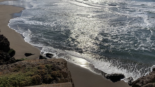 A beach with waves crashing onto the shore, a clear sky, and distant mountains. - Newly Renovated Private Master Suite-10MIN to Golden Gate Park. (San Francisco)