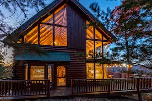 A log cabin with large windows, a porch, and a deck. - ⛰Smoky Mountain Top View🌲King Suite🌲3 LVL Deck🌲Hot Tub🌲Fire Pit🌲Pool Table⛰ (Sevierville)