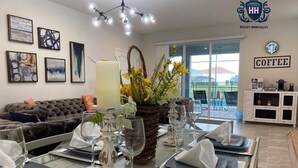 A dining area with a table set for six, a coffee station, and a sofa in the background. - Delightful Frozen Potter Lake Home Pool Spa Resort (Davenport)