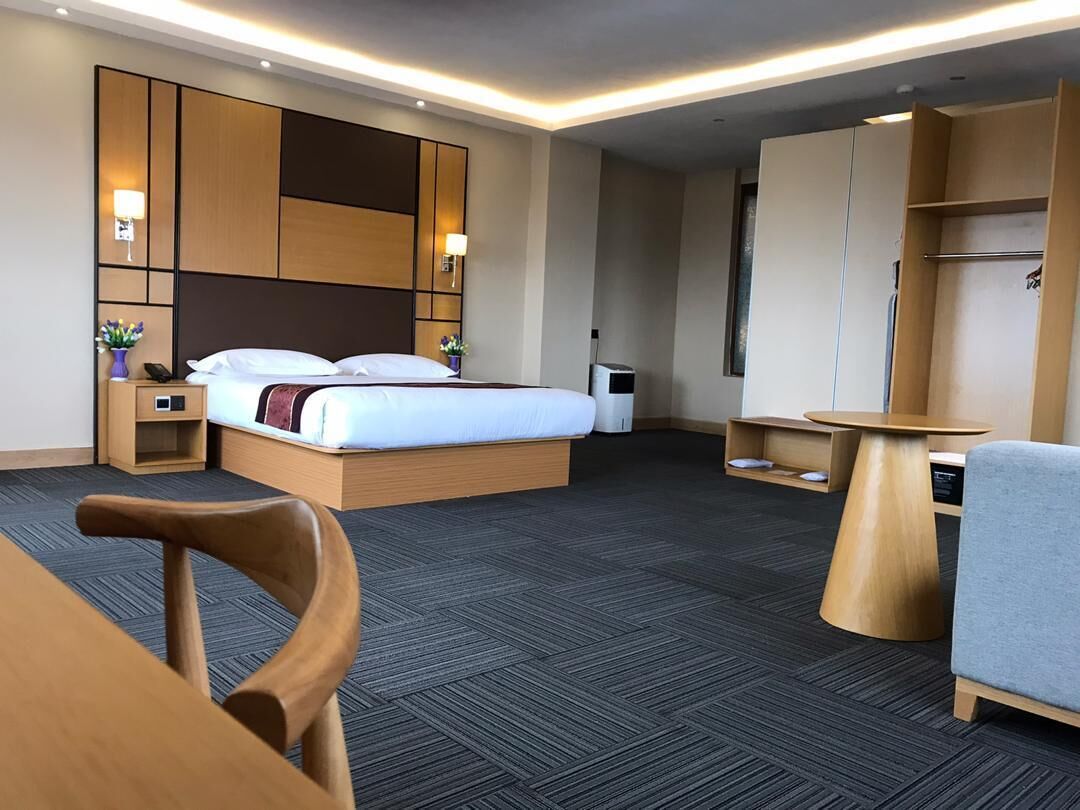 Une chambre d’hôtel moderne équipée d’un grand lit, d’un bureau, d’une chaise et d’une armoire.