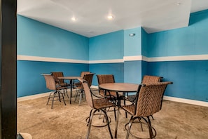 A room with blue walls, a round table, and wicker chairs.
