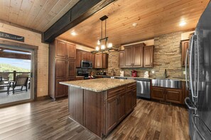 A modern kitchen with wooden cabinets, a granite countertop, and stainless steel appliances.