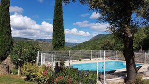 A swimming pool surrounded by a white fence, with a mountainous landscape in the background. - Couiza Gîte du Berger Paris, recent, modern and air-conditioned in a small farmhouse  (Coustaussa)