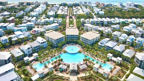 A resort with multiple buildings, a central pool, and a view of the ocean. - Walk to the beach & Lagoon Pool-Bumblebee Cottage (Panama City Beach)