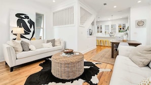 A modern living room with a sofa, coffee table, and a cowhide rug. - Walk to the beach & Lagoon Pool-Bumblebee Cottage (Panama City Beach)