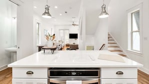 A modern kitchen with a central island, built-in oven, and pendant lighting. - Walk to the beach & Lagoon Pool-Bumblebee Cottage (Panama City Beach)
