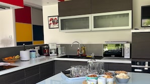 Une cuisine moderne dotée d’un îlot central, d’un four à micro-ondes et d’un four encastré.