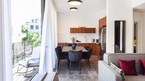 Eine moderne Wohnung mit Balkon, Essbereich und Küche.